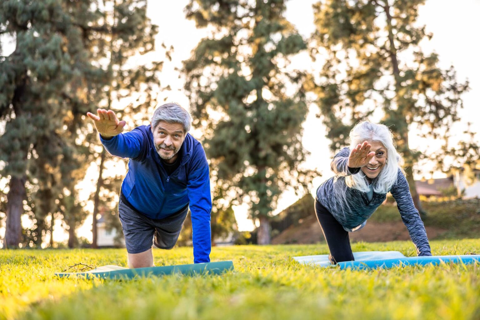 Couple de seniors faisant des exercices de pilates en plein air