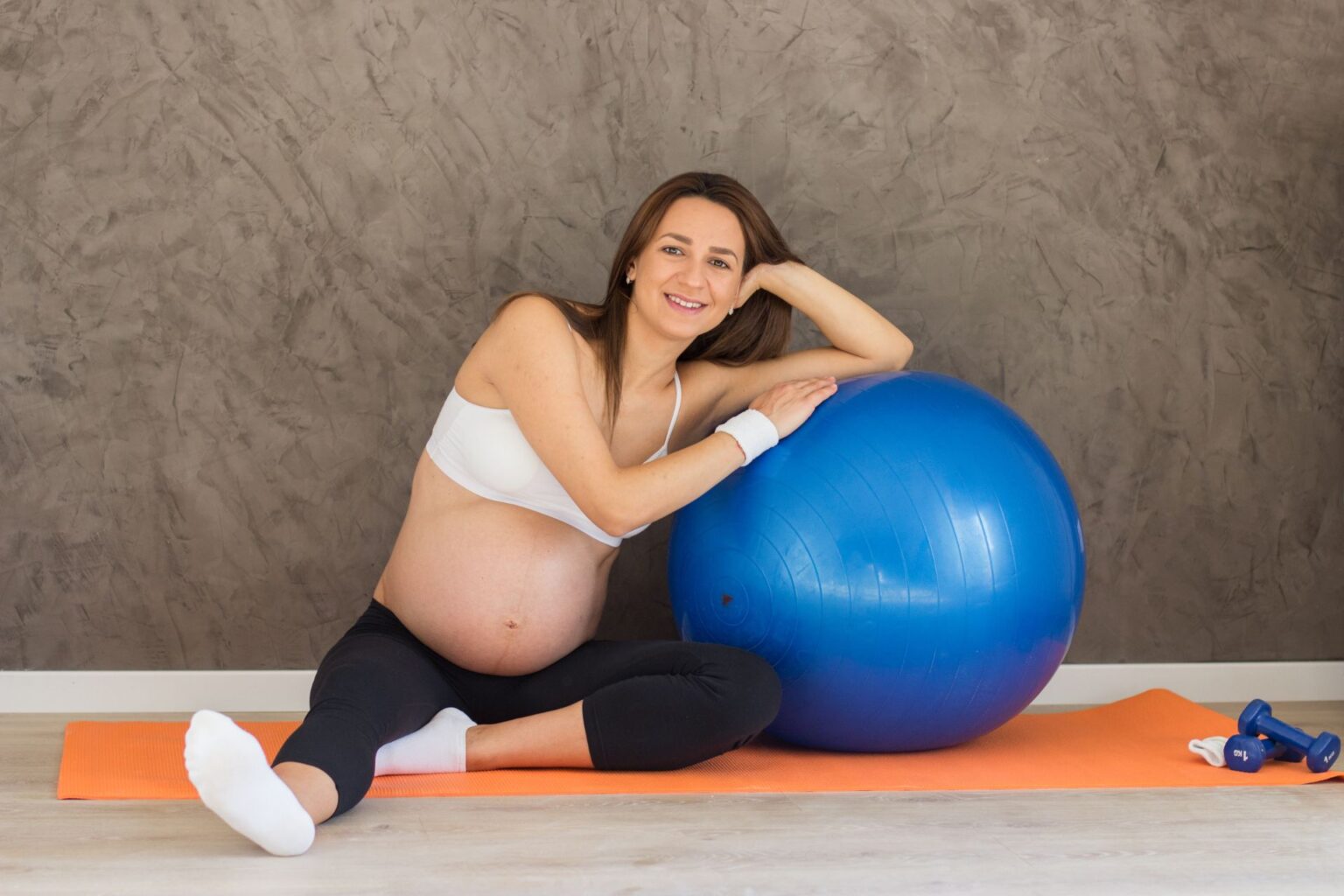 femme enceinte faisant des exercices de pilates pour femmes enceintes sur un ballon de fitness