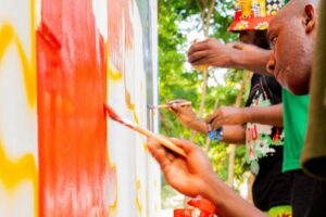 A group of people painting on a wall